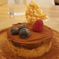 Chocolate dessert topped with a few berries and crispy rice. at Riz Riz - Marais in Paris
