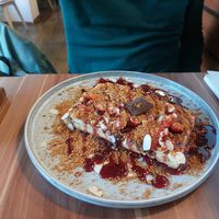Vegan waffle with strawberry, chocolate spread, lotus cookie crumble, almonds, and disgusting blueberry syrup at Cafe Waffle in Prague