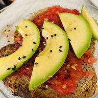 Tostada de pan multicereal y semillas con tomate y aguacate at Dulces Dreams in Malaga