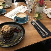 Matcha Pancakes with oat milk cappucino (breakfast burger in the background) at Cafe Elektric in Prague