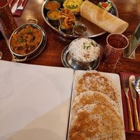 Foreground: Appam, Herbed Kathrika Vazhattiyath (Aubergine curry) at Herb Restaurant in Leicester
