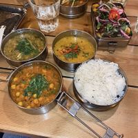 Tiffin lunchbox (the 4 round dishes) + masala potatoes on the square tin at Mowgli - Grand Central in Birmingham