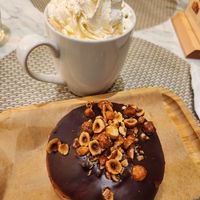 Whipped cream (best ever) on oatmilk latte, with Rocher donut (caramelized hazelnuts and hazelnut pastry cream inside) at L'Artisane Creative Bakery in Coral Gables