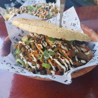 Kebab pieces with garlic and sriracha sauce on a sesame seed bun. at Ping Pong Parck in Amsterdam