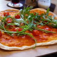 Flatbread with tomato sauce, cherry tomatoes, and rocket leaves, plus garlic (vegan) at Tante Paula im Mailkeller  in Rosenheim