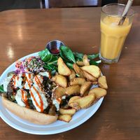 Vegan cheesesteak sandwich with wedges, salad, slaw and organic Jeju mandarin juice  at And 유 (Yu) Cafe in Jeju