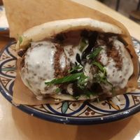 Falafel sandwich with grilled aubergines and a variety of other vegetables and different sauces at Levantine in Paris