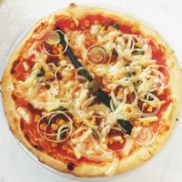 Vegan pizza with vegan cheese, onions, corn, zucchini, asparagus and seitan. at Bullizza in Ljubljana