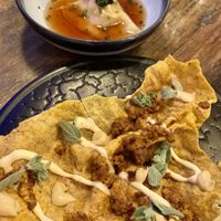 Tofu Empanada (rice cracker with braised tofu, vegan creme fraiche), ordered in advance & Squash dumpling. at Pobrecito in Helsinki