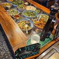 Salad bar with a sign above declaring what you see at Hermans in Stockholm