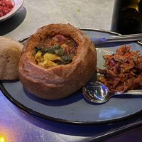 BUNNY CHOW ~ spicy cinnamon-tomato braised chickpea and butternut squash stew burrowed in a crisped sourdough bread bowl served with carrot slaw  at Bang Up To The Elephant in Denver