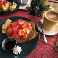 Panqueque de plátano con fruta y café con leche de almendra at Aroma Coffee Bar in Cahuita