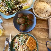 Hummus with grilled veggies, a bowl of falafels and chickpea salad with crispy „schnitzel"  at Hummus Küch' in Frankfurt