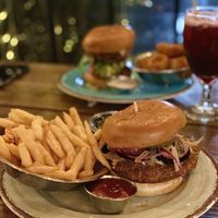 Thai Chick’n Sandwich (w/ fries) in the front, Gorilla Burger (w/ onion rings) in the background, and Sangria at Vida Eatery  in Bakersfield