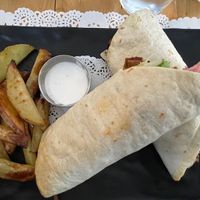 Happy pork wrap: piadina with hand made spicy seitan, salad, tomato, red onion, alioli sauce, mustard and ketchup, with roasted potatoes  at Veg Joy in Rome