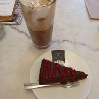 chocolade 'Frambozentaart (vegan) met frambozencoulis' and glass of hot chocomel with whipped cream and marshmallows at Kattencafé Balthazar in Nijmegen