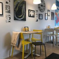 Predominantly white and yellow with fine art on the wall and a large Hergé print.
 at Tuokio in Oulu