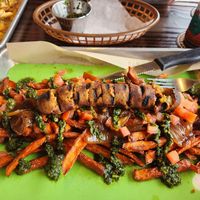 Veggie apple sausage over sweet potatoes with caramelized onions, diced tomatoes, and chimichurri at Bangers & Brews in Bend