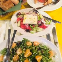Vegan/non vegan dishes. Salat,sesame, raisins, greens, orange. Stuffed tomatoes at Oikeio in Athens