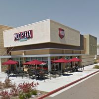 The view from outside with their outside patio tables under umbrellas at Mod Pizza in Downey