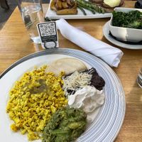 In front Huevos Rancheros, back Eggs Benedict & sauteed kale. at Blossom Restaurant on Columbus in New York City