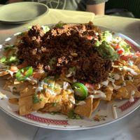 Amazing nachos. We added the chorizo and guacamole. This is the large size.   at Rosalinda in Toronto
