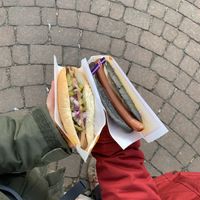 Vegan hot dog with pickled cucumbers (left) and black sheep dog (right)   at Akureyri Hot Dog Stand in Akureyri