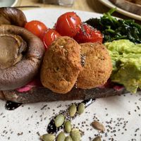 Smashed avo, wilted spinach, garlic mushrooms, falafel and grilled toms with beetroot hummus on sourdough toast sprinkled with chia and pumpkin seeds (vegan). at Trading Post Coffee Roasters in Lewes