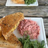 Vegan cheese and red onion marmalade toasties on granary bread, with homemade vegan coleslaw and micro greens. at Peak Feast in Bakewell