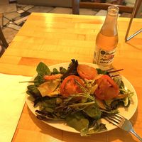 Garden salad with peach dressing and slices of peaches 🍑   at Zia Gourmet Pizza in San Diego