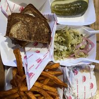 Ruben, burger, with the side combo of pickles, coleslaw, and sweet potato fries   at Beaut Burger in Tucson