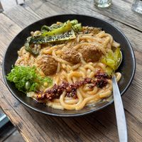 Ben ben noodles = creamy sesame sauce, udon, meatballs, pak soy, crispy chili oil, scallions, pickles at SOIL Vegan Cafe - West in Amsterdam