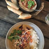 White bean hummus and peanut curry bowl with smoked tofu and rice at SOIL Vegan Cafe - West in Amsterdam