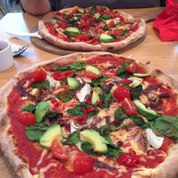 Mama-V. Delicious vegan pizza with chilli, spinach, radicchio, cherry tomatoes, fresh avocado and vegan mozzarella. Other pizzas can also be veganised. The bruschetta is vegan too. at Mama J's in Looe