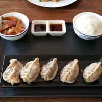 Dumplings with sauce and sides at Lucky Dumpling in Zurich