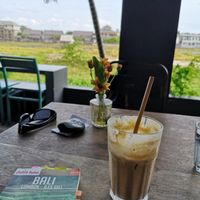 Latte with coconut milk in front of the rice fields at District Canggu in Tibubeneng