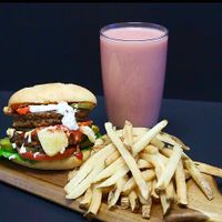 Seitan Beet Burger served on a ciabatta bun with lettuce, tomato and onions, topped with vegan mayo, ketchup and mustard. at FGF VEGAN - Famous Good Food in Oshawa