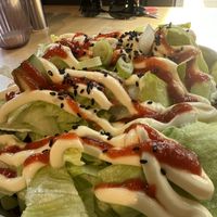 There was shoarma, vegan cheese, and sweet potato fries below the lettuce with mayo and sriracha  at The Black Cockatoo in Almere