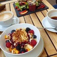 Soya cappucchino und veganes porridge, im Hintergrund das hummusbrot at Cafe Hilda in Kiel