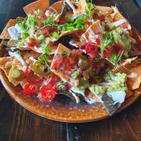 Sharing nachos - tortilla chips, chili peppers, guacamole and vegan mayo. Couldn't resist a nibble before I took the photo at Church - Temple of Fun in Sheffield