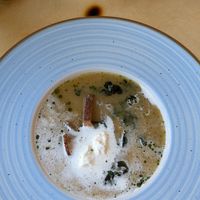 Typical Polish soup called Żurek (soup made with cucumber leaven) which here comes with vegan sour cream, smoked crispy tofu, kale crisps, potatoes and oil (pumpkin seed oil) at Naturalna in Bydgoszcz