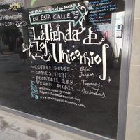 Sign on busier street showing restaurant directions at La Tienda de Los Unicornios in Granada