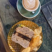 Toast of cheese, avocado and tomato with flat white   at La Tienda de Los Unicornios in Granada