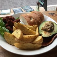 Lunch plate with fried soy meat, potato wedges, avocado stuffed with mushrooms and a side of bread.  at Marugoto Vegan Dining Asakusa in Tokyo