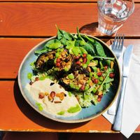 Bowl with creamy eggplant, green rice, pomegranate, spinach and hummus at Nah am Wasser - Neukölln in Berlin