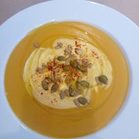 Pumpkin soup as an entree, with cream, pumpkin seeds and spices. Intense flavors. at Giusto Restaurante Vegano in Torrevieja