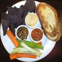 Healthy Trio - black and green olive tapenade, housemade hummus, and tomato-mango salsa served with toasted bread, tortilla chips and raw veggies. at Ethos Vegan Kitchen in Winter Park