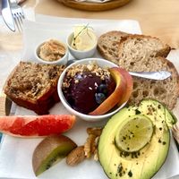 Cake, small açaí bowl, bread, butter, hummus, avocado, fruits and nuts   at Coffee & Waves in Lagos