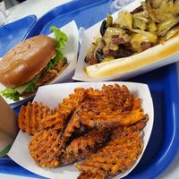 Betterfinger shake, deluxe chicken sandwich, philly cheesesteak, and sweet potato fries at Meta Burger in Denver