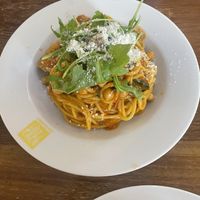 Spaghetti with tomato-based sauce, vegan sausage, and chickpeas. Topped with vegan Parmesan and arugula.  at Pasta Factory in Galway
